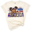 A cute black baby girl with an afro hairstyle wearing patriotic red, white, and blue Independence Day attire.