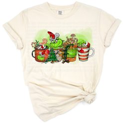 A cartoon grumpy green character holding a coffee cup with festive Christmas decorations.