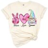 Whimsical gnome with peace sign, pink sunflowers, and tie dye hearts in a playful Valentine’s Day scene.