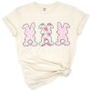 Three pastel bunnies with floral and flower accents in pink and teal hues.