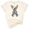 A charming portrait of a bunny surrounded by blue and pink roses in a floral arrangement.