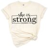 Uplifting phrase She Is Strong with modern feminine script and subtle religious design elements.