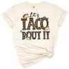 A fun cartoon taco wearing a western hat surrounded by fiesta and Mexican party decorations.