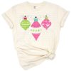 A festive pink and green ornament with polka dots and a cheer bow in a playful holiday design.