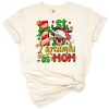 A festive holiday design featuring the phrase 'First Christmas as Mom' with cheerful seasonal elements.