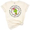 A whimsical green character face with a mischievous holiday expression wearing a red Santa hat.