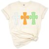Three colorful crosses in a line with blue, orange, and green tones on a white background