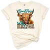 Boho highland cow with a humorous and sarcastic expression on a rustic background.