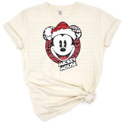 A festive cartoon mouse wearing holiday attire in a Christmas themed scene.