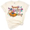 Watercolor illustration of a rabbit with decorated eggs and daisy flowers in a western spring theme.