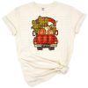 A vintage red truck filled with pumpkins and colorful autumn leaves.